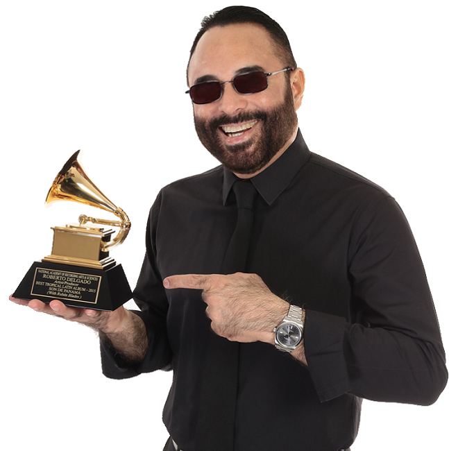 Roberto Delgado sosteniendo un Grammy en la mano