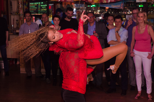 Bailarines vestidos de rojo bailando en el bar latino La Macumba