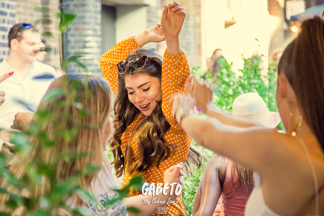 Mujer con vestido anaranjado bailando en el Bar / Restaurante Gabeto 